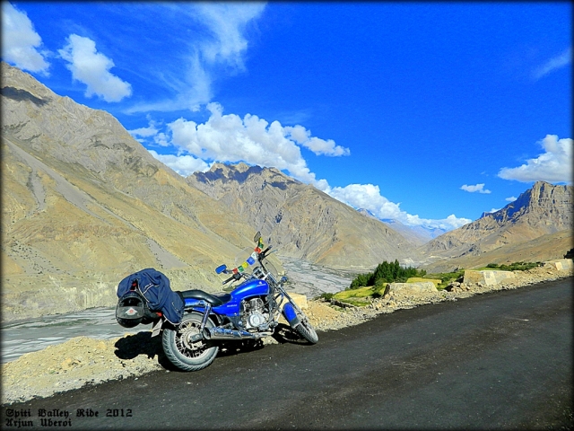 motorcycle set against massive hills and mountains in the spiti valley